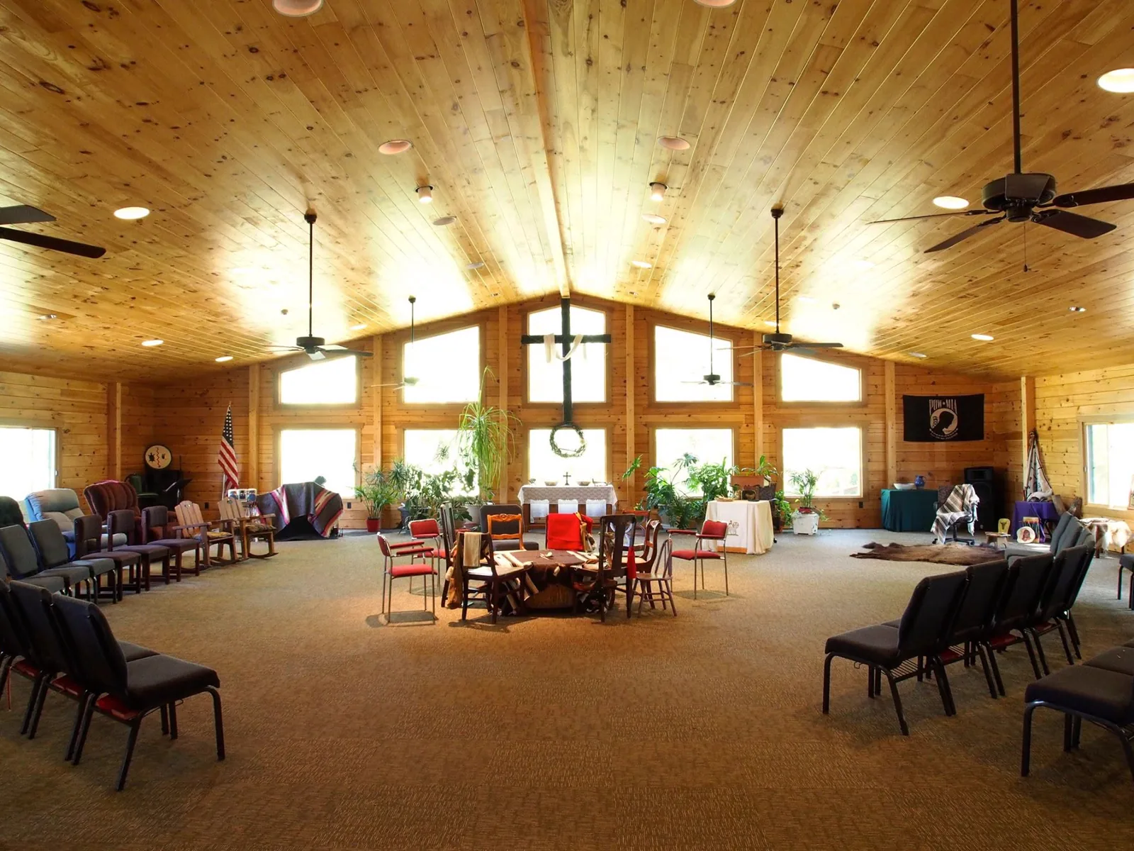 The worship space, with chairs set in a circle around the drum beneath a high pine ceiling.